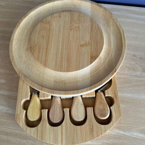Tabla de aperitivo de madera redonda con cuchillos